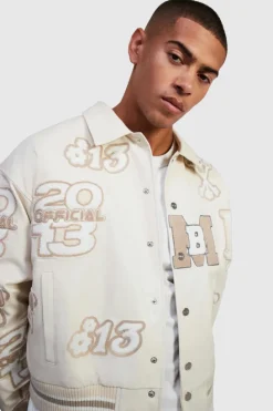 Online boohooMAN Boxy Pu Tonal Badge Varsity Jacket ecru