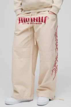 Shop boohooMAN Elasticated Waist Parachute Acid Wash Ripstop Printed Trousers stone
