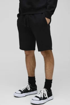 Shop boohooMAN Loose Fit Mid Length BM Signature Shorts black