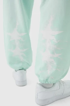 Shop boohooMAN Oversized Worldwide Spray Wash Printed Joggers turquoise