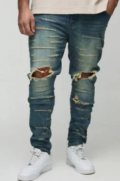 Shop boohooMAN Plus Extreme Rip Busted Knee Skinny Jeans mid wash