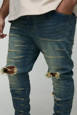 Shop boohooMAN Plus Extreme Rip Busted Knee Skinny Jeans mid wash