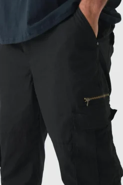 Shop boohooMAN Plus Slim Flare Zip Gusset Overdye Acid Wash Cargo Trouser In black