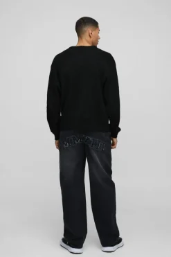 Shop boohooMAN Relaxed Rigid Acid Wash Applique Denim Jeans black