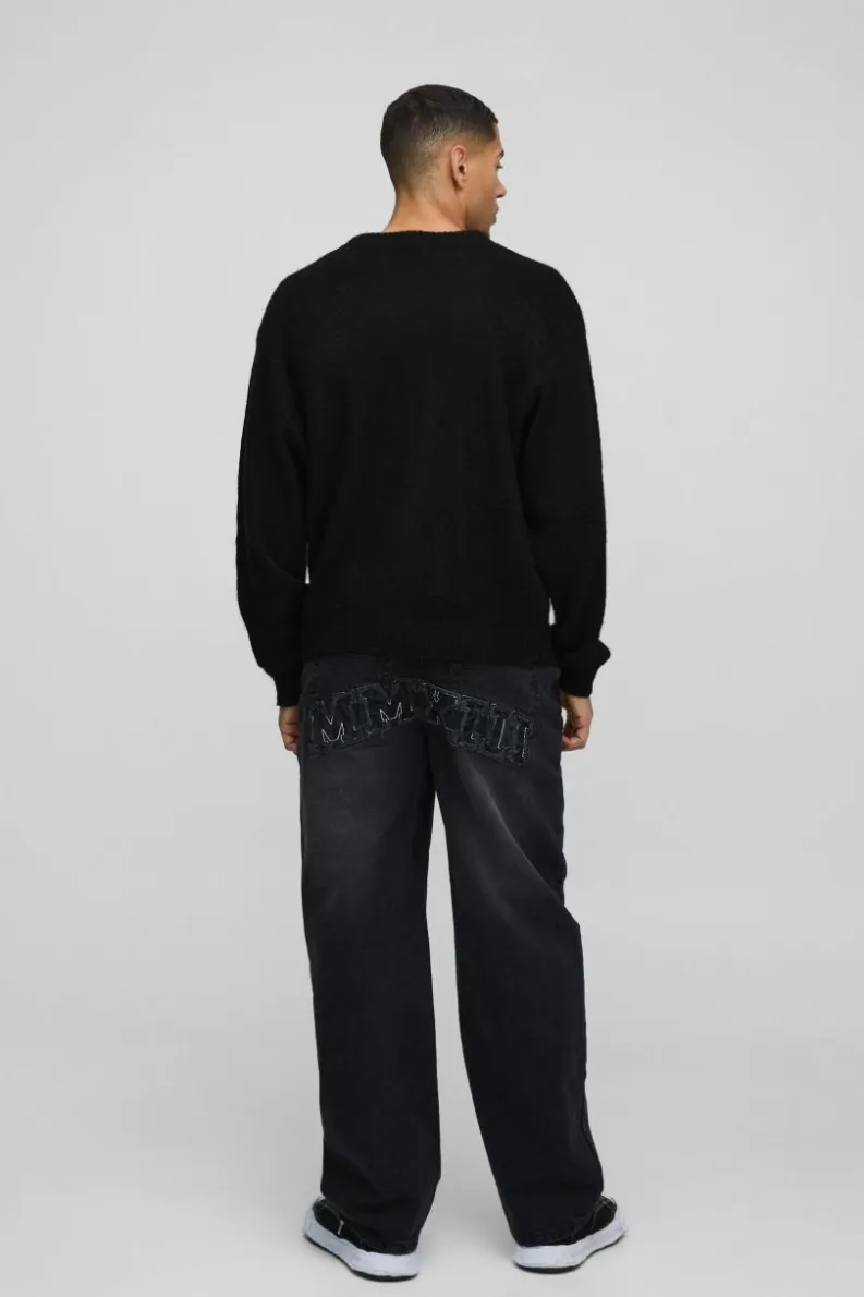 Shop boohooMAN Relaxed Rigid Acid Wash Applique Denim Jeans black
