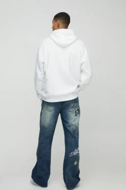 Store boohooMAN Relaxed Rigid Flared Gusset Varsity Applique Badge Jeans vintage blue