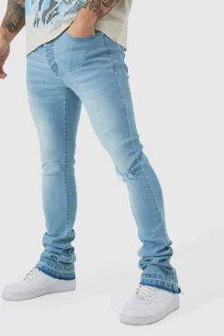 Shop boohooMAN Skinny Stacked Flared Jeans With Knee Rip light blue