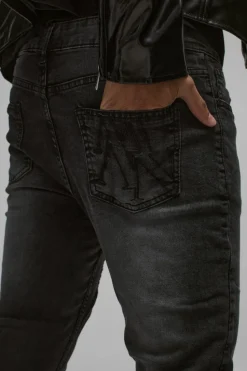 Shop boohooMAN Skinny Stretch Stacked Biker Rip & Repair Jeans true black