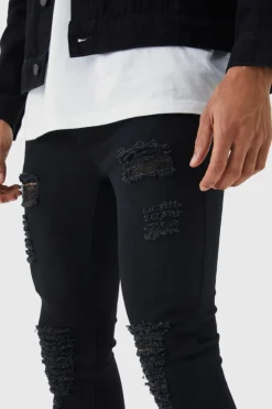 Store boohooMAN Super Skinny Jeans With All Over Rips true black