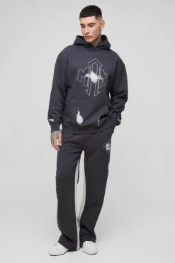 Shop boohooMAN Tall Oversized Man Paint Splatter Hooded Relaxed Flare Tracksuit black